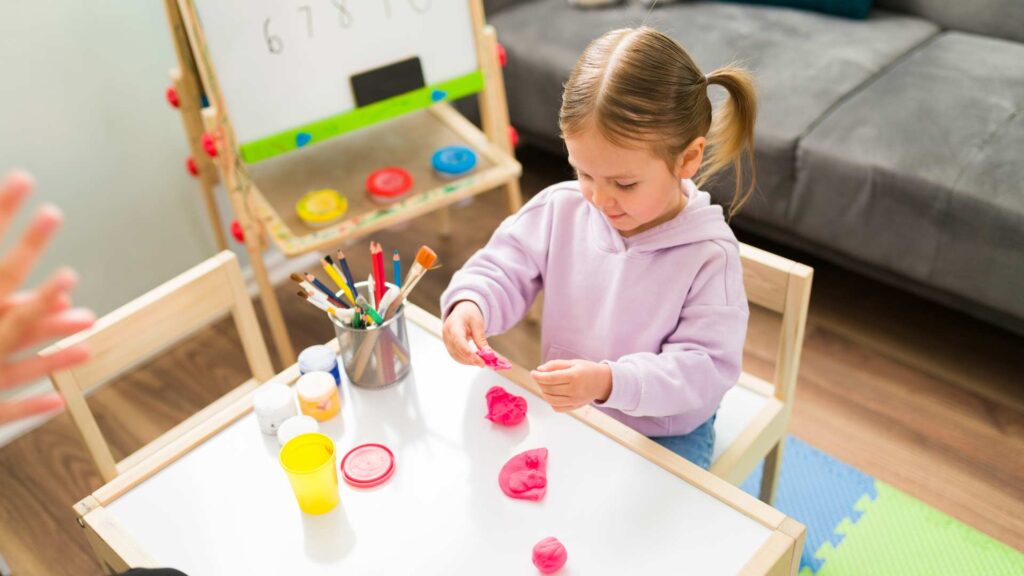 Adult guiding a child during a learning activity at home, showing a calm in‑home ABA therapy moment