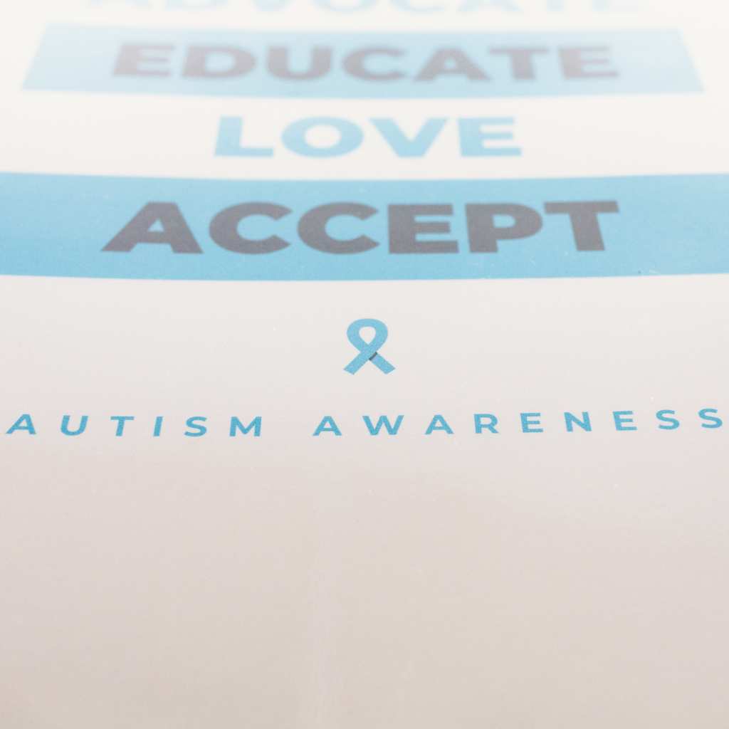 Autism awareness ribbon with supportive words above it