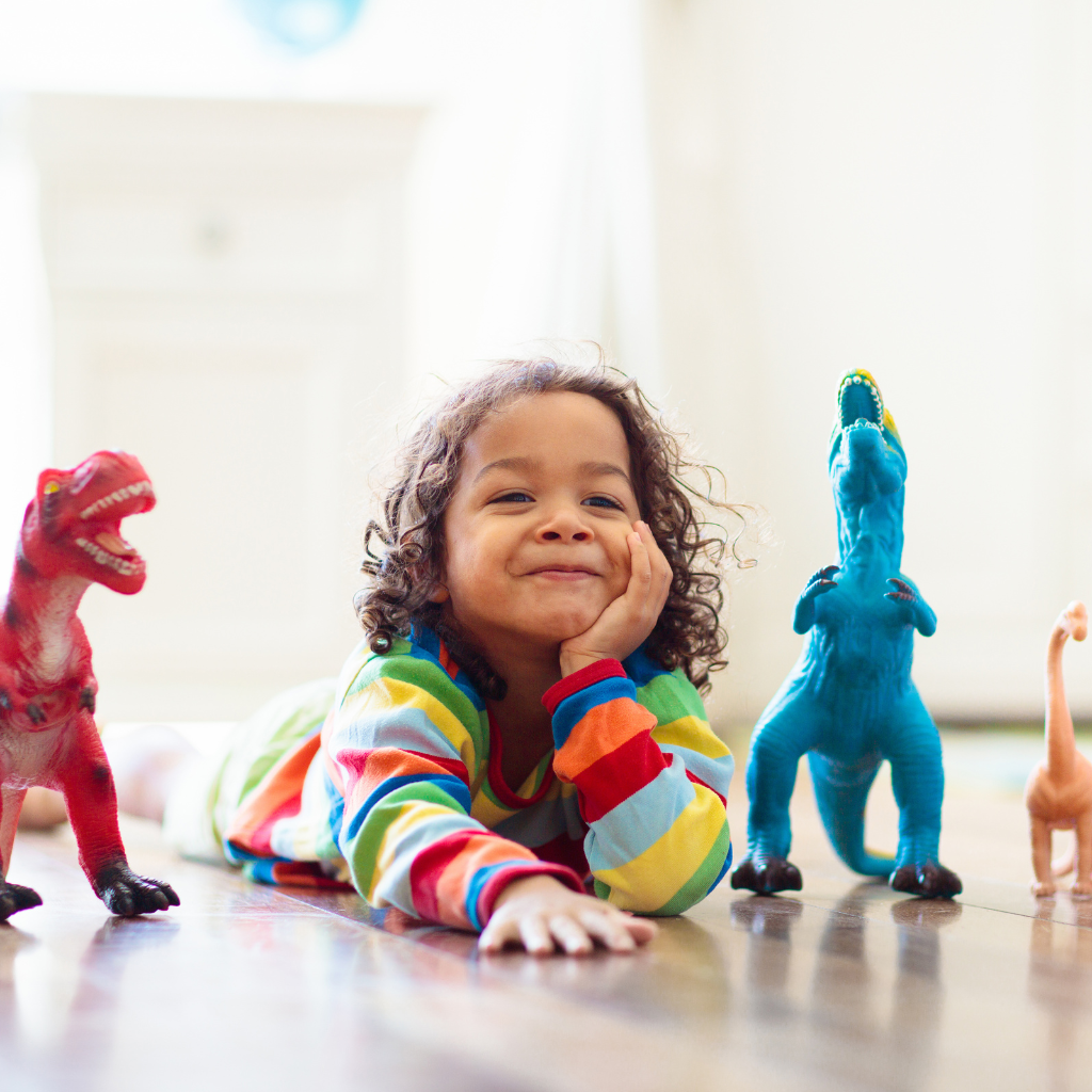 Child playing with dinosaur toys, showing how autism representation in toys supports confidence, empathy, and play-based learning.