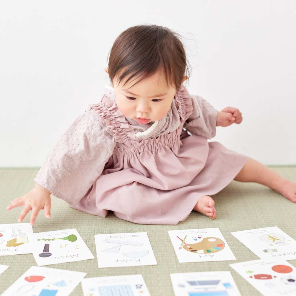 Toddler reaching for educational flashcards during an early intervention activity